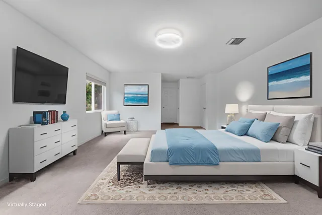 a bedroom with a large bed and a flat screen tv