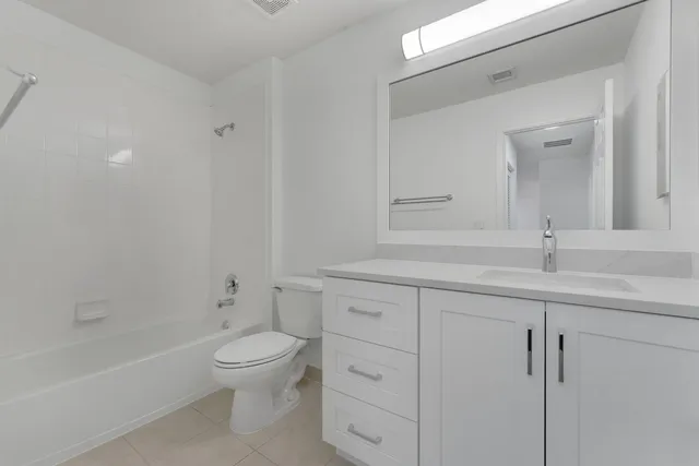 a bathroom with a toilet a sink a mirror and bathtub