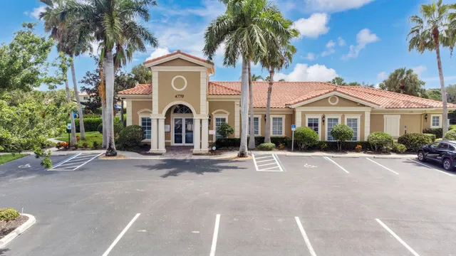 a front view of a house with a garden and trees