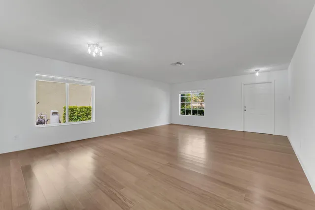 an empty room with wooden floor and a window