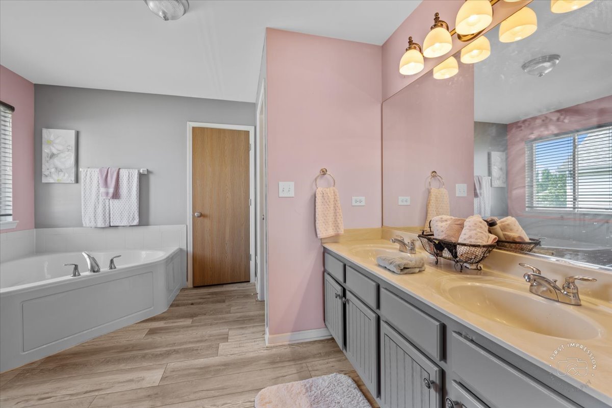 511 Silver Falls Street Joliet, IL 60431 - Photo 13 of 35 a bathroom with a tub sink and mirror