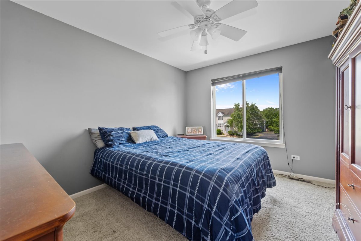 511 Silver Falls Street Joliet, IL 60431 - Photo 15 of 35 a bedroom with a bed chandelier and a window