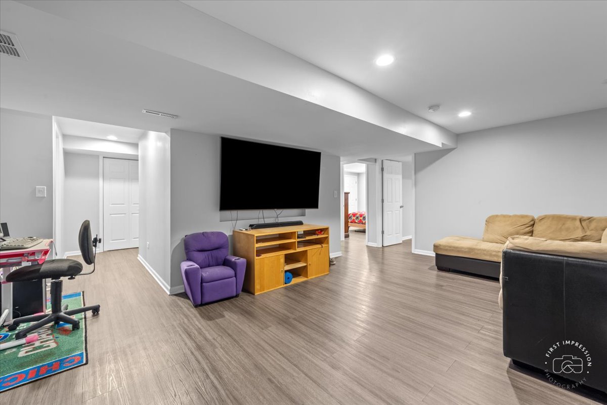 511 Silver Falls Street Joliet, IL 60431 - Photo 19 of 35 a living room with furniture and a flat screen tv