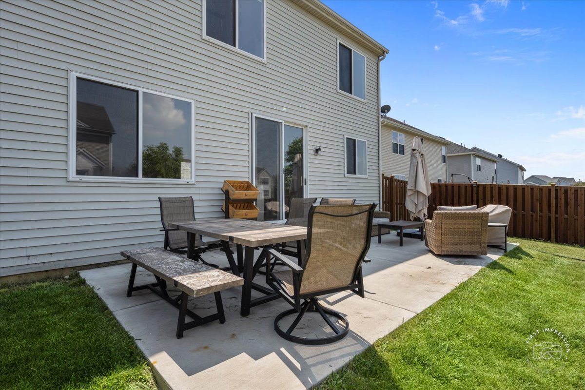 511 Silver Falls Street Joliet, IL 60431 - Photo 25 of 35 a view of a patio with table and chairs a barbeque with wooden fence