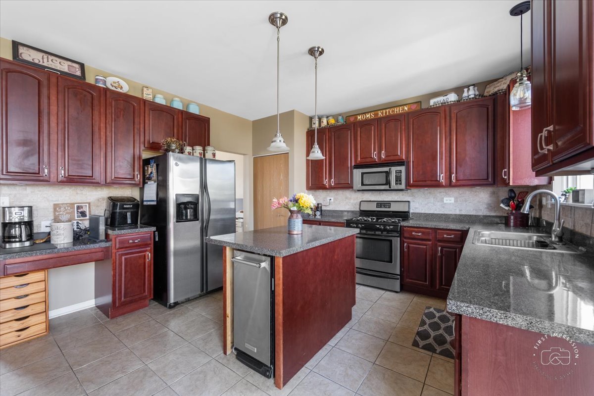 511 Silver Falls Street Joliet, IL 60431 - Photo 4 of 35 a kitchen with stainless steel appliances granite countertop a stove top oven a refrigerator a sink and dishwasher