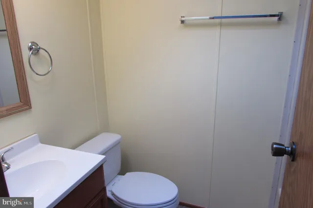 a bathroom with a granite countertop toilet and a sink