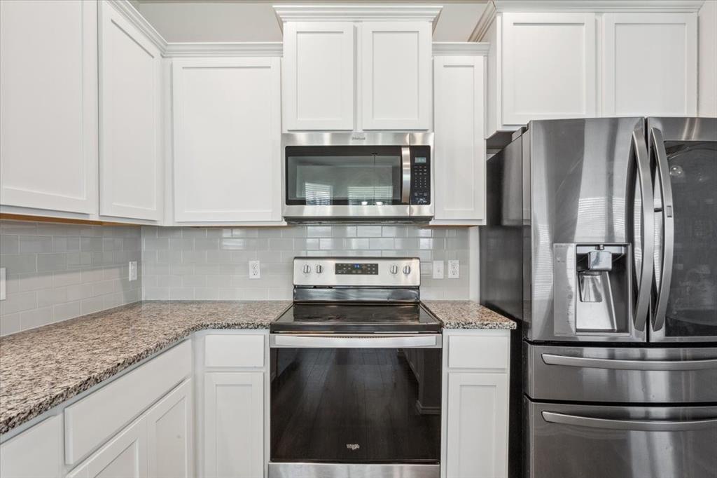3220 Marston Road Lorena, TX 76655 - Photo 17 of 40 a kitchen with stainless steel appliances granite countertop a stove microwave and refrigerator