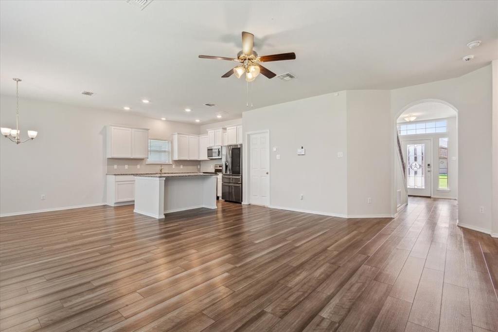 3220 Marston Road Lorena, TX 76655 - Photo 8 of 40 a view of an empty room with wooden floor and a kitchen