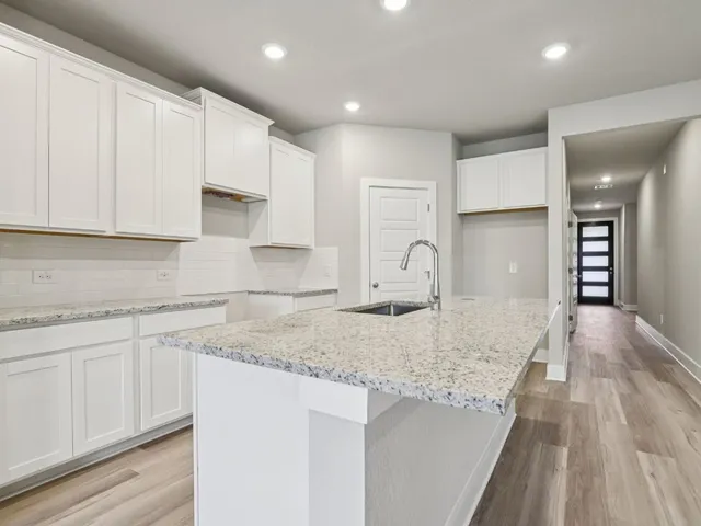 a kitchen with stainless steel appliances granite countertop a sink stove and white cabinets