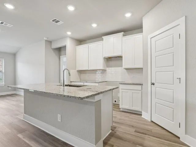 a kitchen with a sink window and cabinets