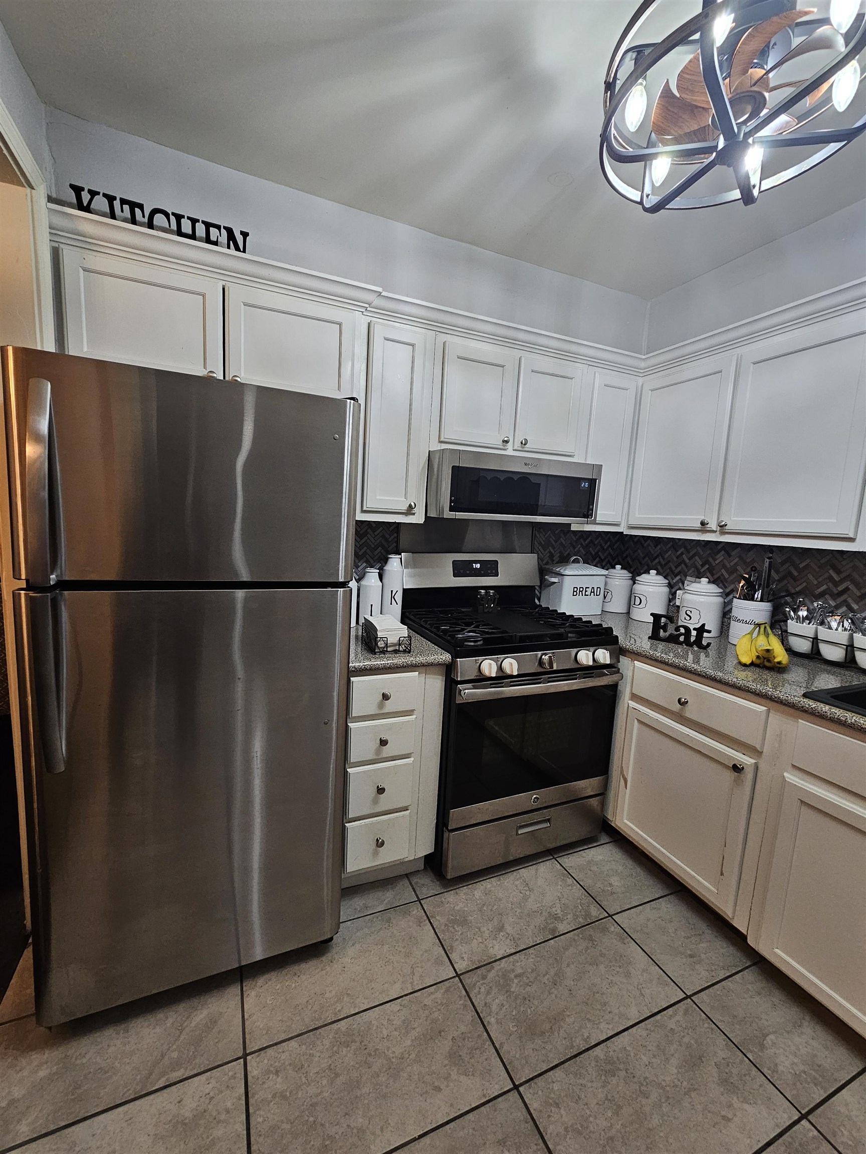 1534 Railton Road Memphis, TN 38111 - Photo 5 of 28 Kitchen with appliances with stainless steel finishes, tasteful backsplash, light tile patterned flooring, and white cabinets