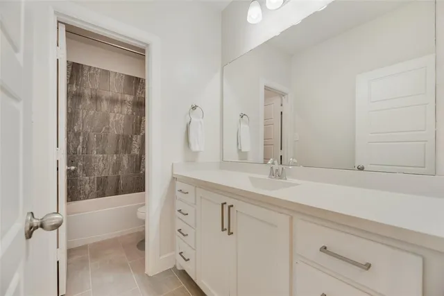 a bathroom with a sink and a mirror with bathtub