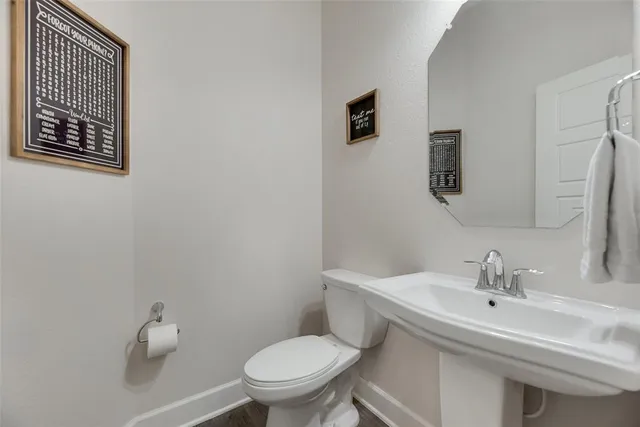 a bathroom with a sink mirror and toilet