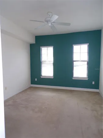 an empty room with a window and a ceiling fan