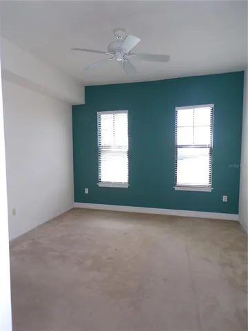 an empty room with a window and a ceiling fan