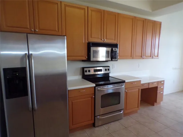 a kitchen with stainless steel appliances granite countertop a stove a refrigerator and a microwave