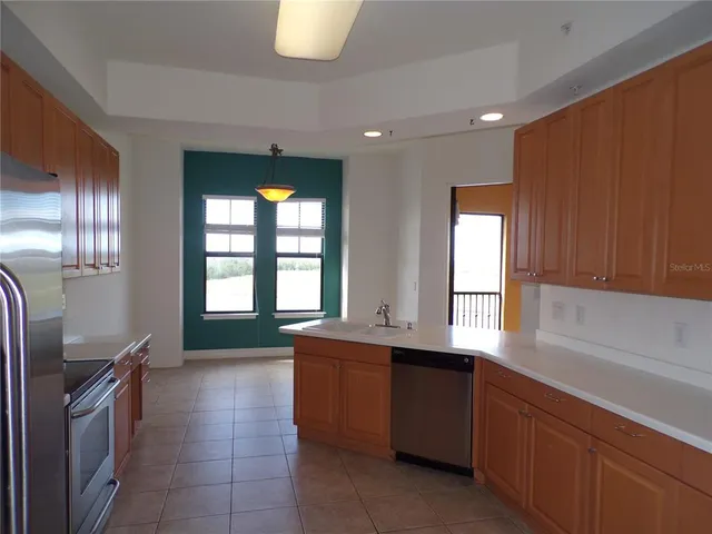 a kitchen with stainless steel appliances granite countertop a sink a stove and a refrigerator