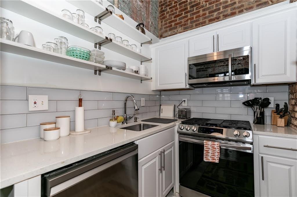 170 Boulevard Southeast, Unit 131H Atlanta, GA 30312 - Photo 17 of 47 a kitchen with stainless steel appliances a sink a stove and cabinets