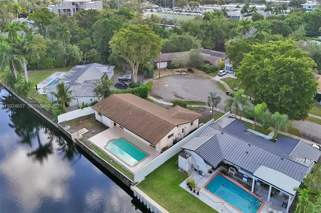 an aerial view of a house with swimming pool and outdoor seating