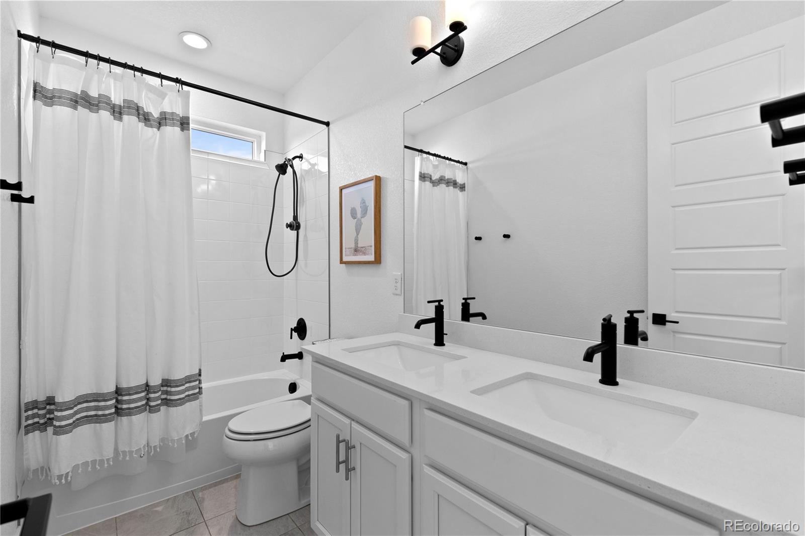 6058 North Perth Street Aurora, CO 80019 - Photo 40 of 47 a bathroom with a sink a toilet a mirror and shower