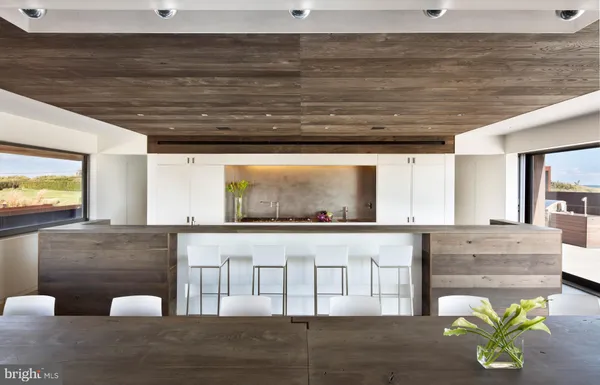 a living room with stainless steel appliances granite countertop furniture and a wooden floor