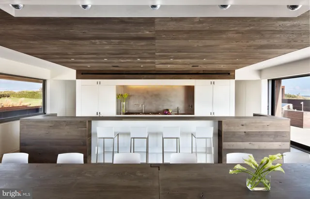 a living room with stainless steel appliances granite countertop furniture and a wooden floor