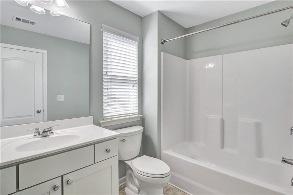 330 Avalon Square Fairburn, GA 30213 - Photo 42 of 52 a bathroom with a sink toilet vanity and shower