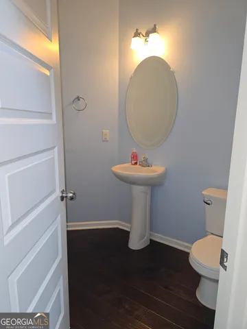 a bathroom with a toilet a sink and a mirror