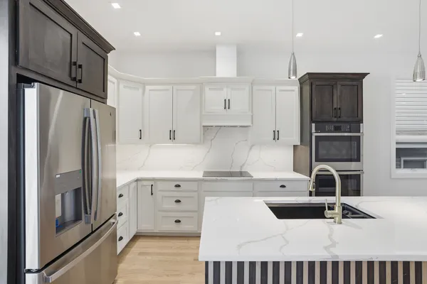 a kitchen with stainless steel appliances kitchen island granite countertop a refrigerator and a stove top oven