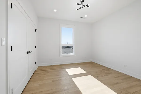 an empty room with a window and ceiling fan