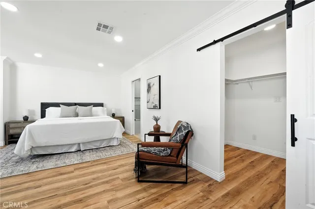 a bedroom with a bed and wooden floor