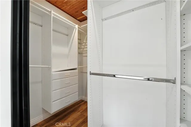 a view of walk in closet with empty racks