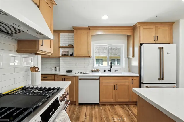 a kitchen with stainless steel appliances a stove a sink and a refrigerator