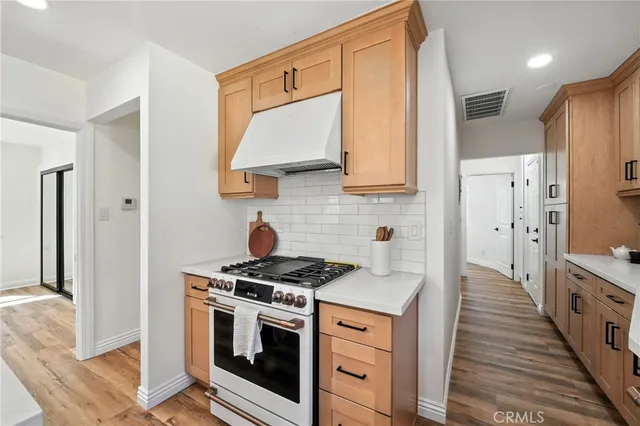 a kitchen with stainless steel appliances a stove a sink and a refrigerator