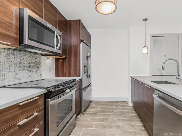 a kitchen with stainless steel appliances granite countertop a stove and a microwave
