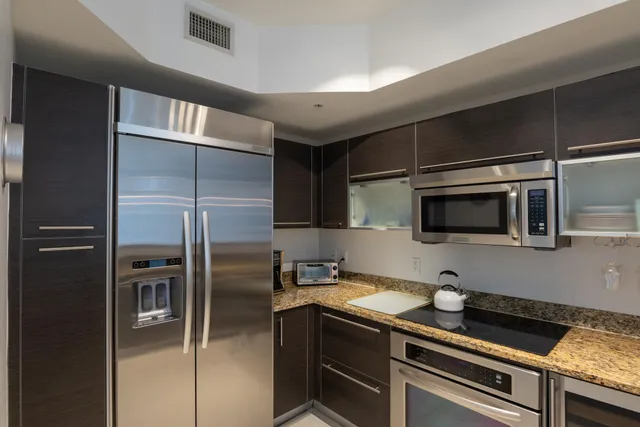 a kitchen with stainless steel appliances granite countertop a refrigerator and a sink