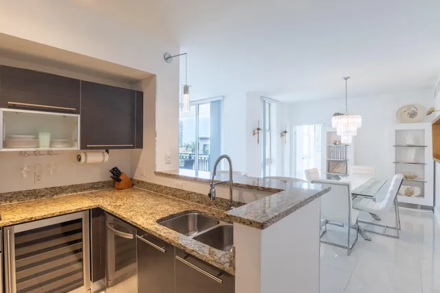 a kitchen with granite countertop a sink and a refrigerator