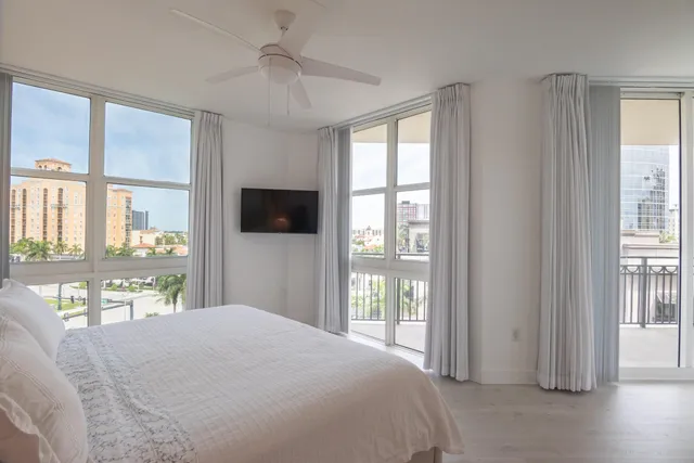 a bedroom with a large bed and a flat tv screen