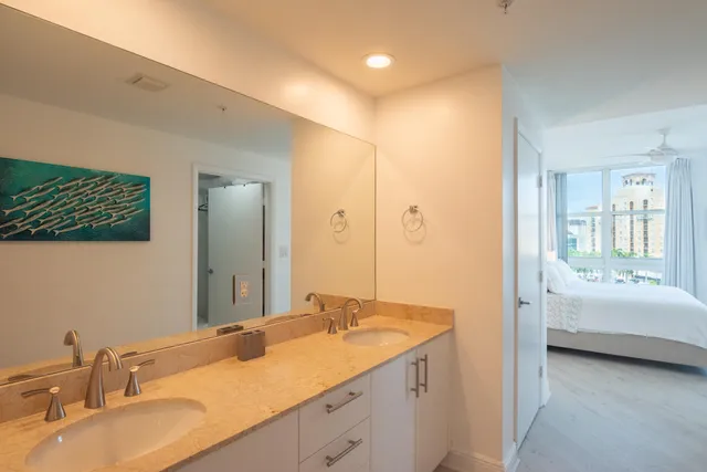 a bathroom with a sink double vanity granite tub shower and a mirror