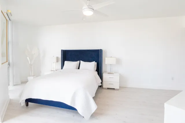 a bedroom with a bed and a white wall