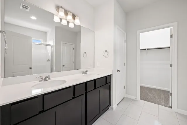 a bathroom with a sink double vanity and a mirror