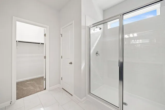 a bathroom with a glass shower door and a glass door