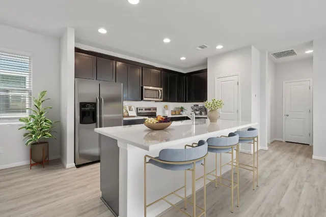 a kitchen with kitchen island granite countertop a sink and refrigerator
