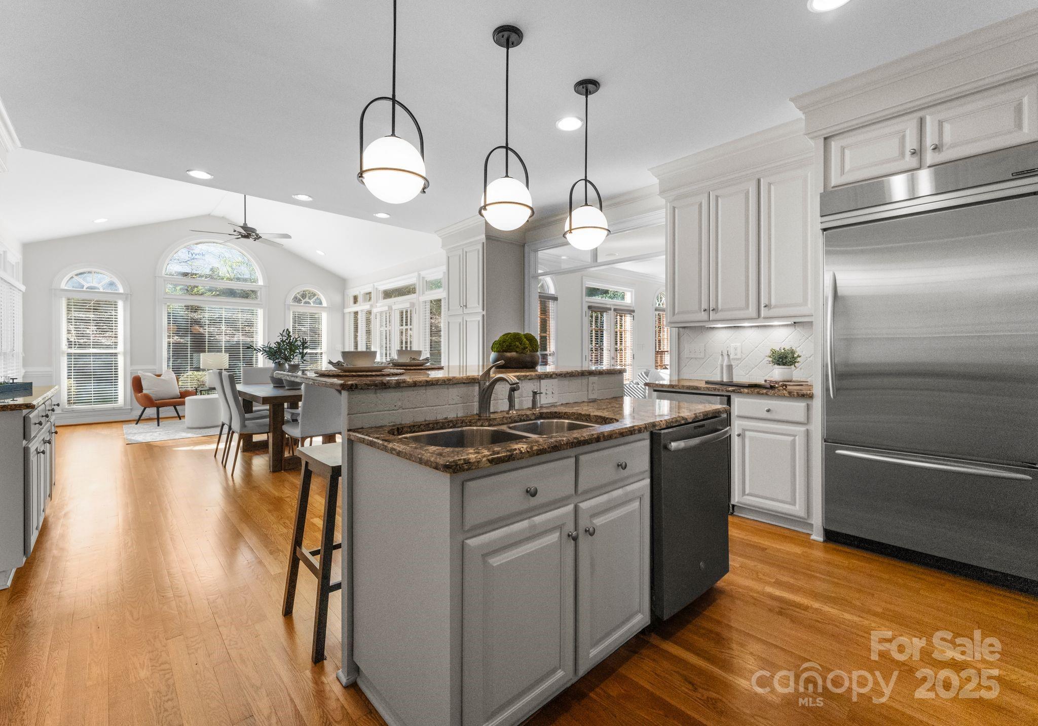 1604 Windy Ridge Road Charlotte, NC 28270 - Photo 17 of 39 a kitchen with stainless steel appliances granite countertop a stove a sink dishwasher and a refrigerator with wooden floor