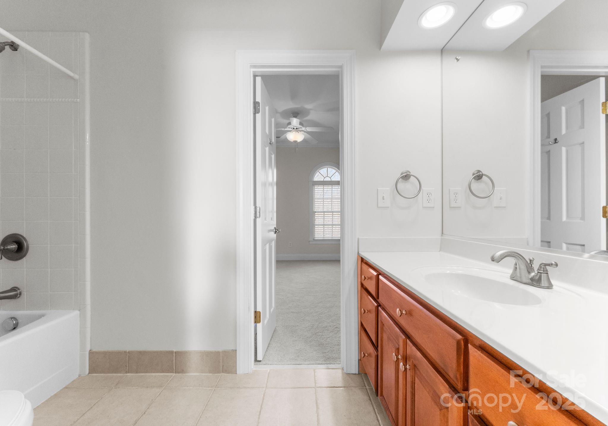 1604 Windy Ridge Road Charlotte, NC 28270 - Photo 20 of 39 a bathroom with a sink a mirror and a bathtub