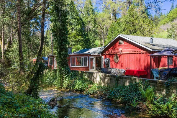 a view of a house with a yard and potted plants