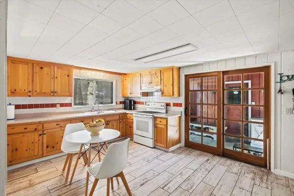 a kitchen with a table chairs microwave and cabinets