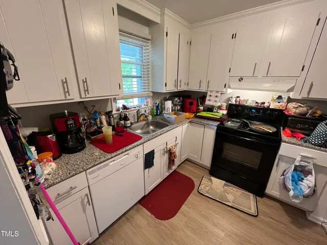 a kitchen with a stove and white cabinets