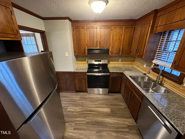 a kitchen with stainless steel appliances granite countertop a sink stove and refrigerator