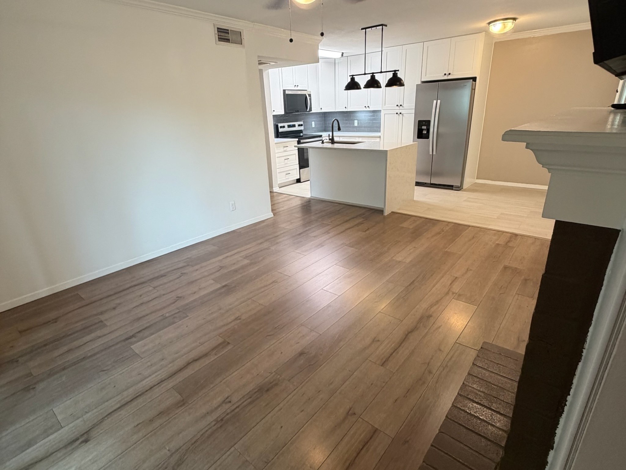 3500 Tangle Brush Drive, Unit 65 Spring, TX 77381 - Photo 10 of 20 Spacious living area offers plenty of flexibility for furniture placement, with warm wood-look flooring and an open sightline to the beautifully updated kitchen and dining space.